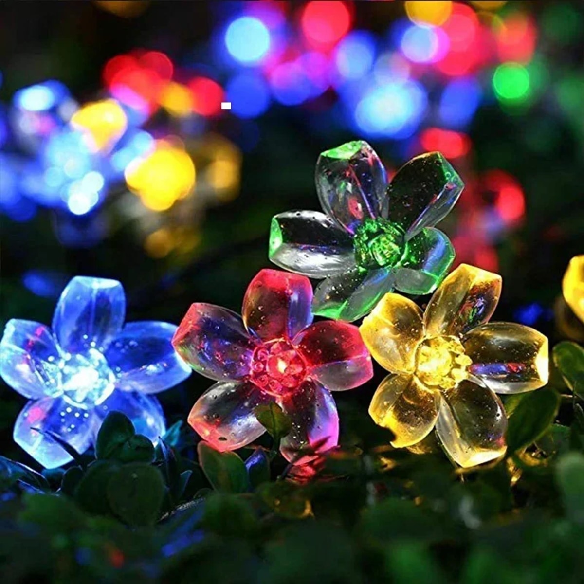 Cordão floral de LED solar colorido com flores acesas no jardim